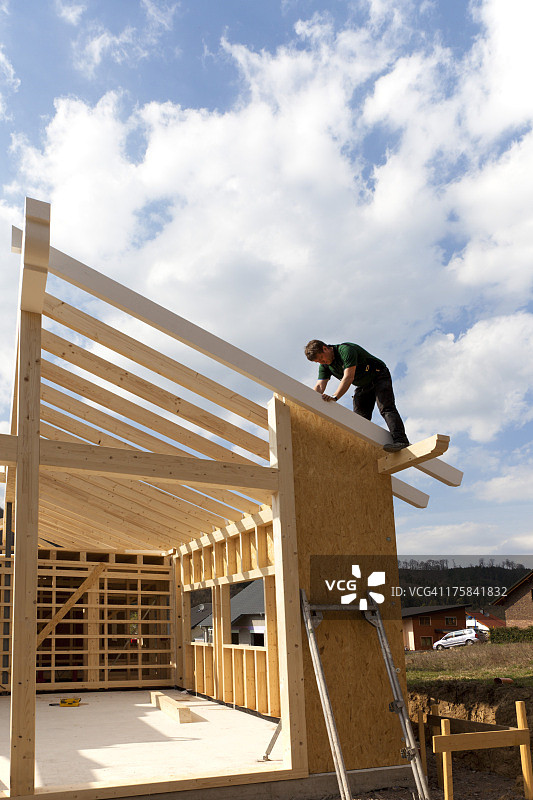 欧洲德国莱茵兰-普法尔茨：男子安装和固定预制房屋的木墙图片素材