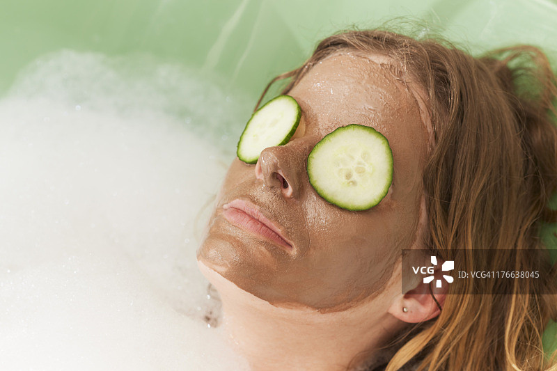 中年妇女在浴缸里敷泥面膜，特写图片素材