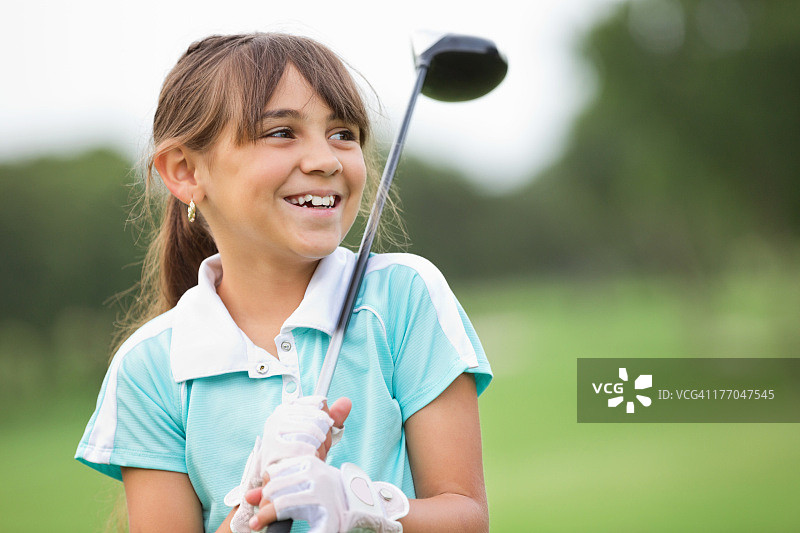 在乡村俱乐部打高尔夫的快乐小女孩图片素材