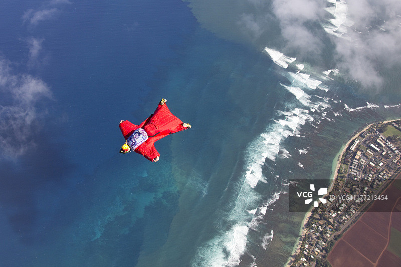 身着翼装的跳伞运动员飞越海洋图片素材