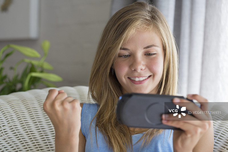 玩电子游戏的微笑女孩特写图片素材