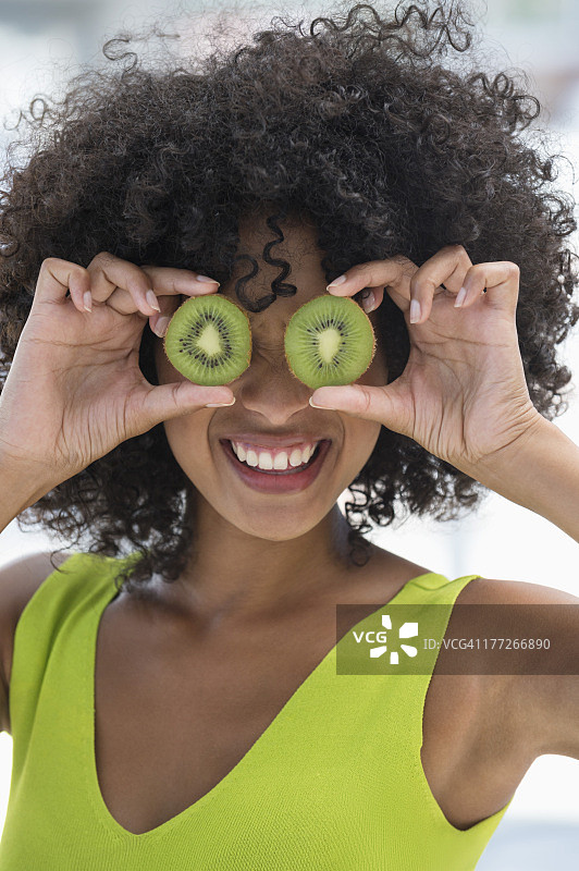 女人用猕猴桃挡住眼睛图片素材