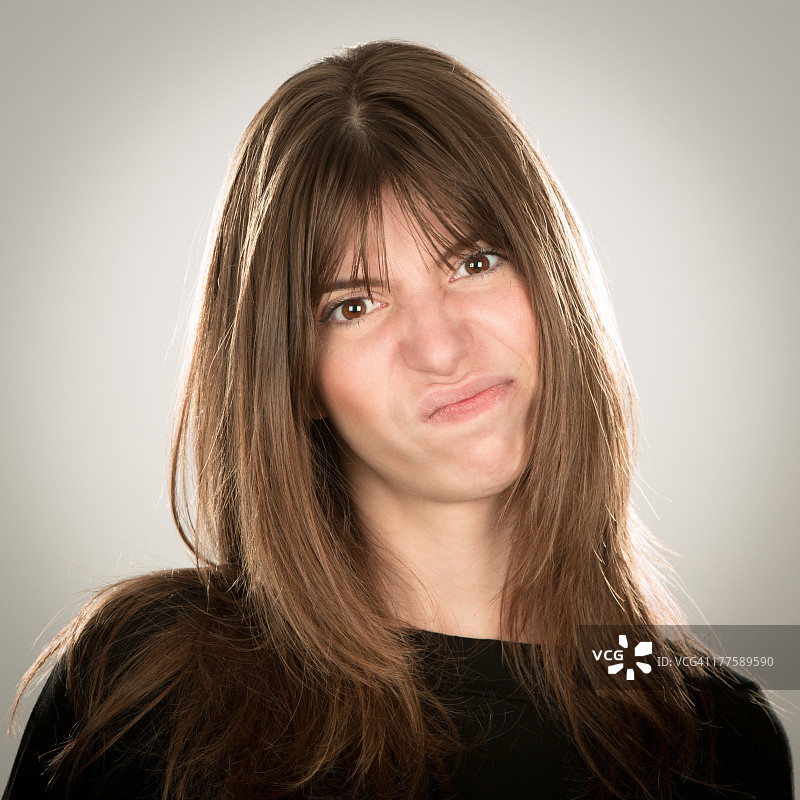 表情严肃的直长发年轻女子肖像图片素材