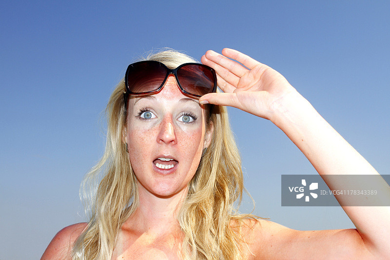 女人抬起太阳镜图片素材