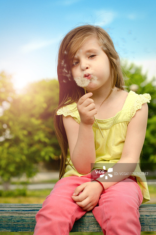 吹蒲公英的小女孩图片素材