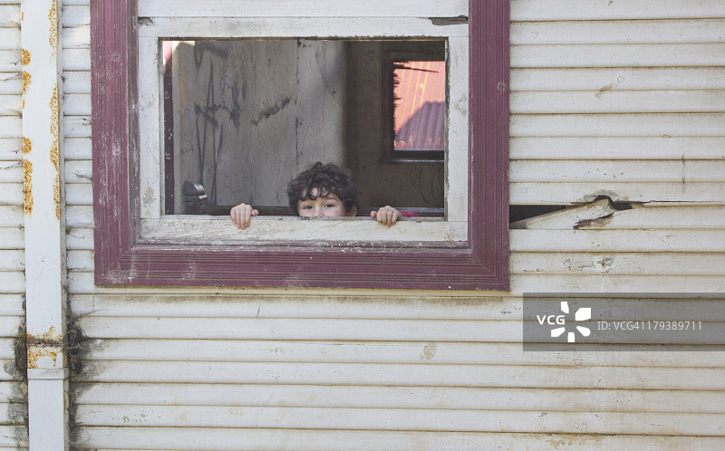 在破损窗户旁的孩子图片素材