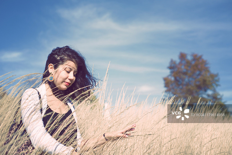 在田野里玩耍的年轻女人图片素材