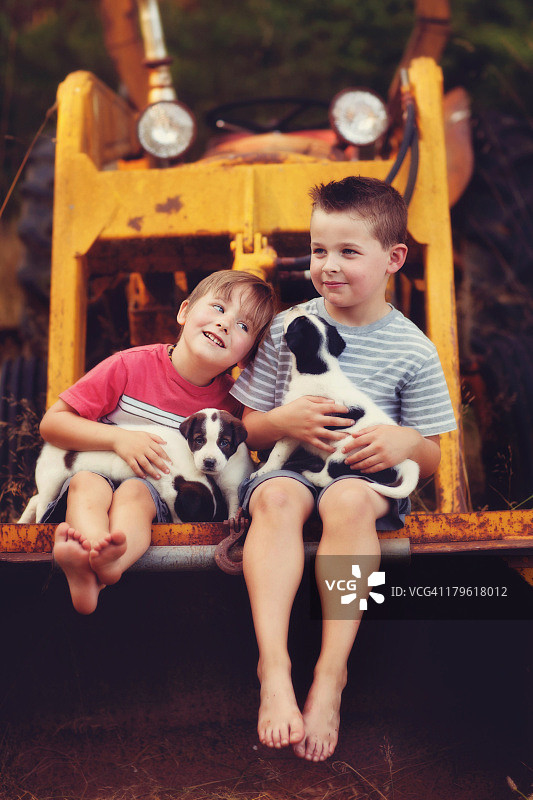在拖拉机上的儿童与小狗图片素材