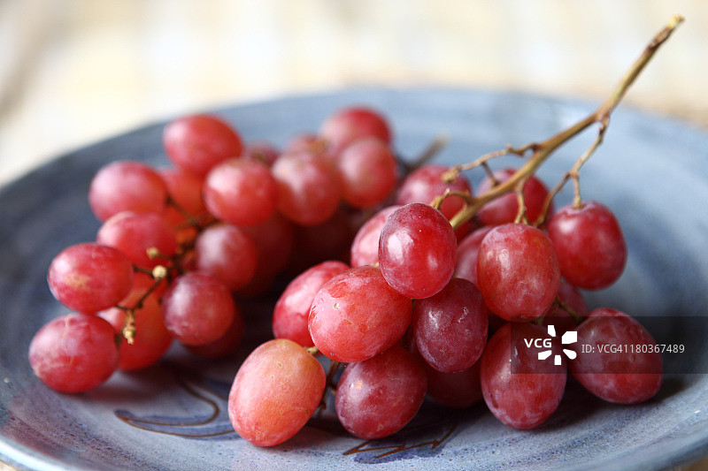 蓝色盘子上的红葡萄图片素材