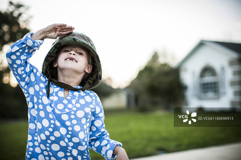 戴军用头盔的年轻女孩敬礼图片素材