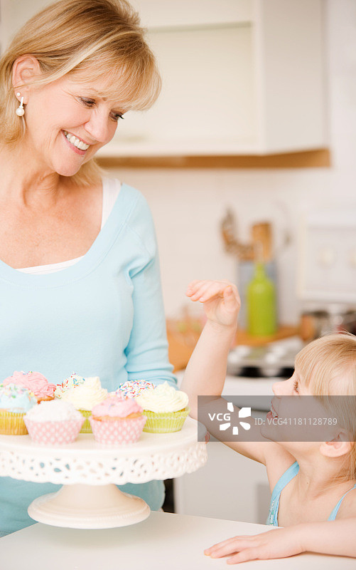 中年妇女和孩子吃纸杯蛋糕图片素材