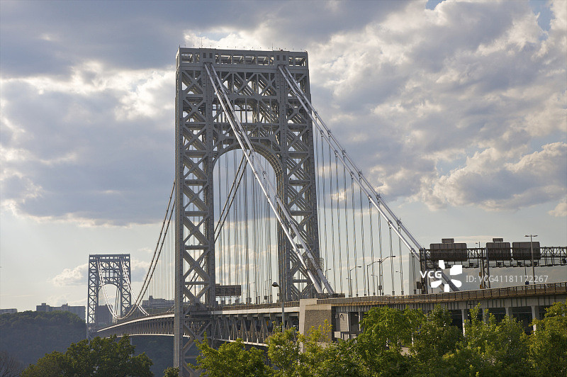 绿色树木顶部的桥梁灰色缆线和塔架图片素材