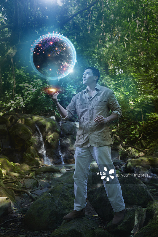 丛林中带有电脑屏幕投影的亚洲男人图片素材