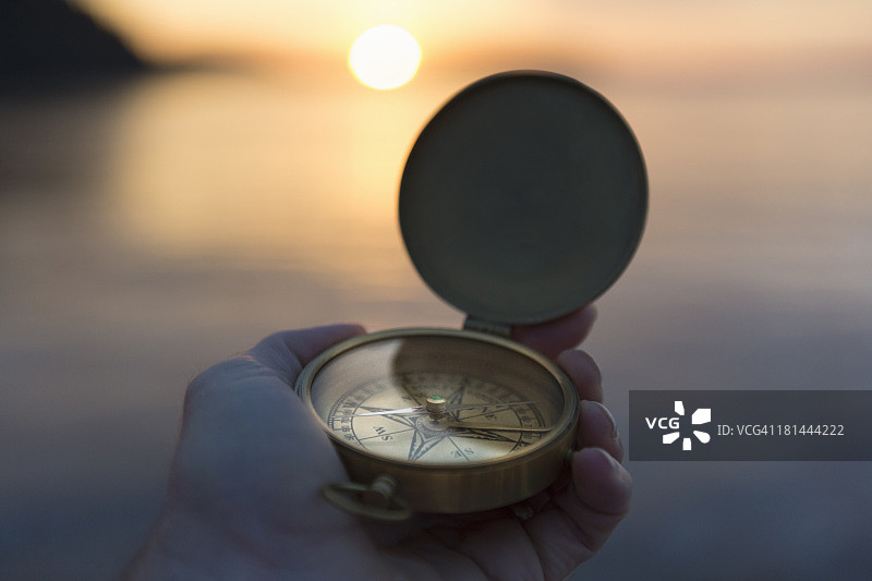 古董指南针与水面日出图片素材