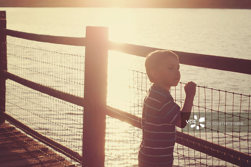 小男孩在湖边眺望图片素材
