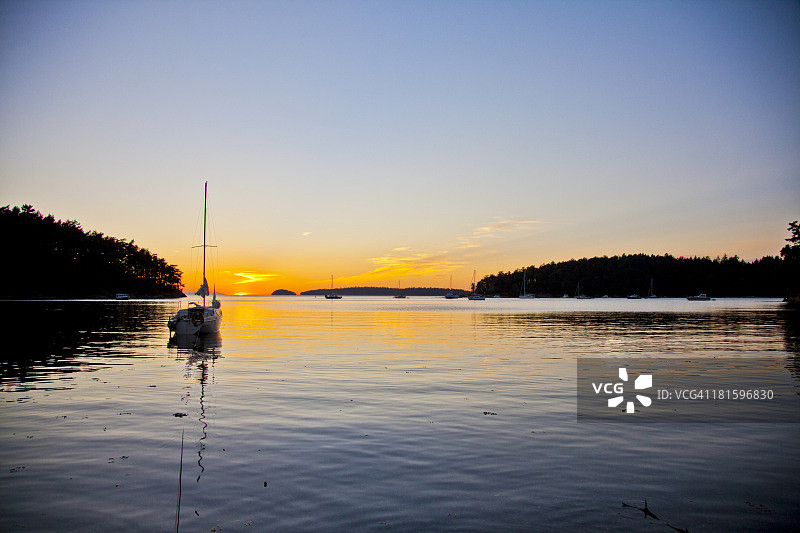 日落时分，漂浮在水面上的帆船图片素材