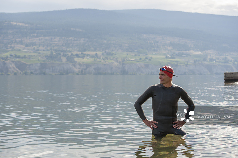 站在湖边浅水区的铁人三项运动员肖像图片素材