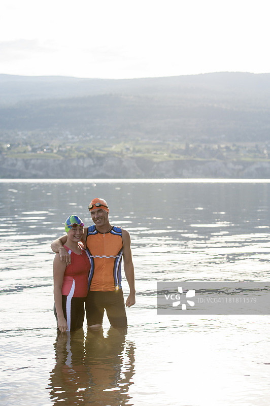 父亲和女儿铁人三项运动员的肖像，湖图片素材