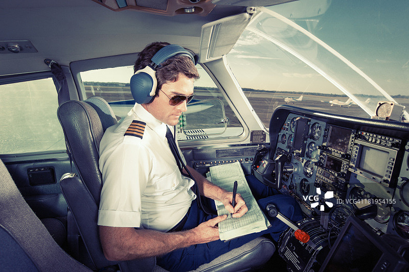 小型通勤飞机驾驶员在日志中书写图片素材