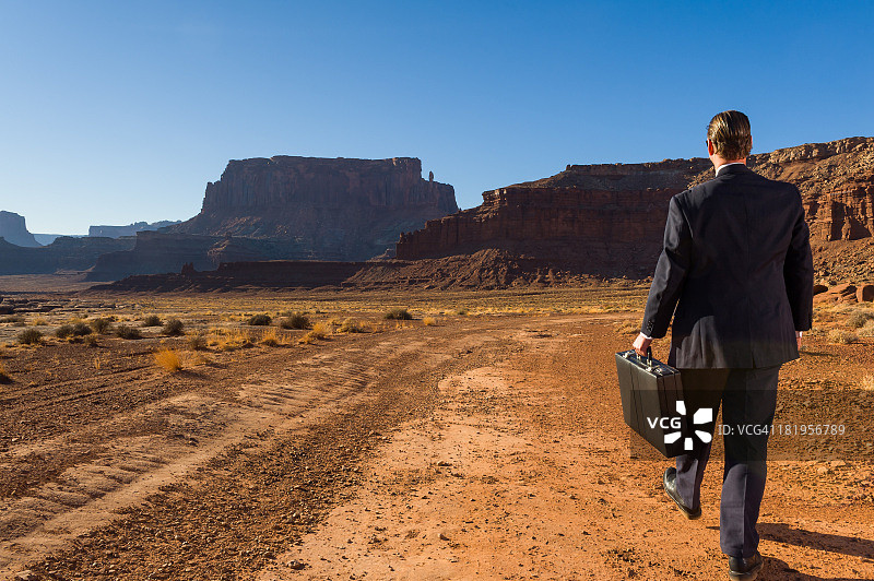 在荒凉的风景中走开的商务男士图片素材