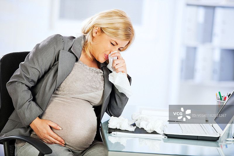 年轻孕妇擤鼻涕图片素材