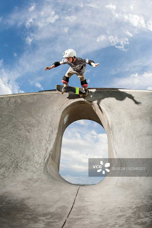 在特殊地形上玩滑板的年轻滑板运动员图片素材