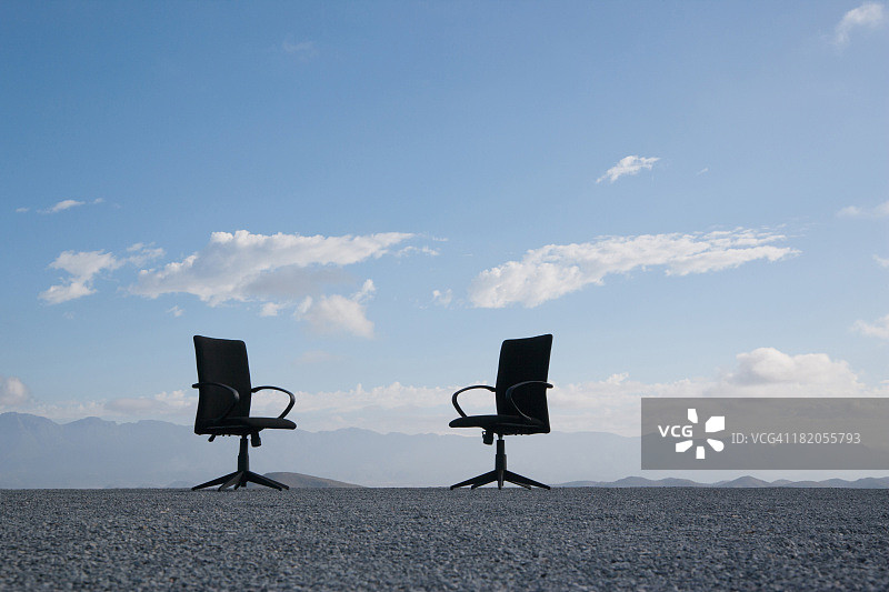 布满鹅卵石地面上的两把办公椅图片素材