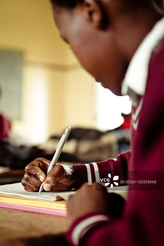 南非女孩在书桌前写作特写图片素材