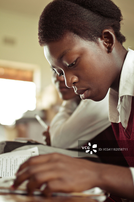 南非女孩在书桌前写作特写图片素材