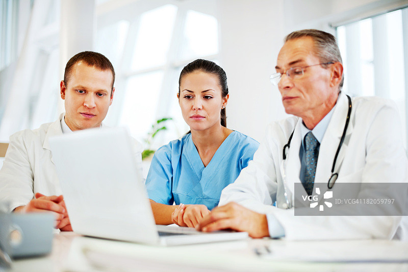 三位医生使用笔记本电脑工作图片素材