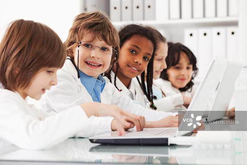 使用笔记本电脑的多元种族儿童群体图片素材