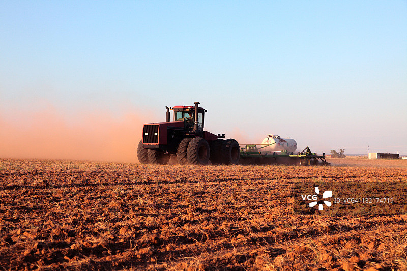 农业：农民驾驶拖拉机在耕地上施肥图片素材
