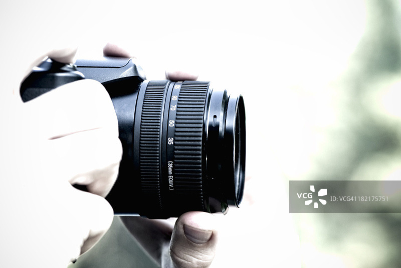 摄影师手持专业相机，高调，留白图片素材