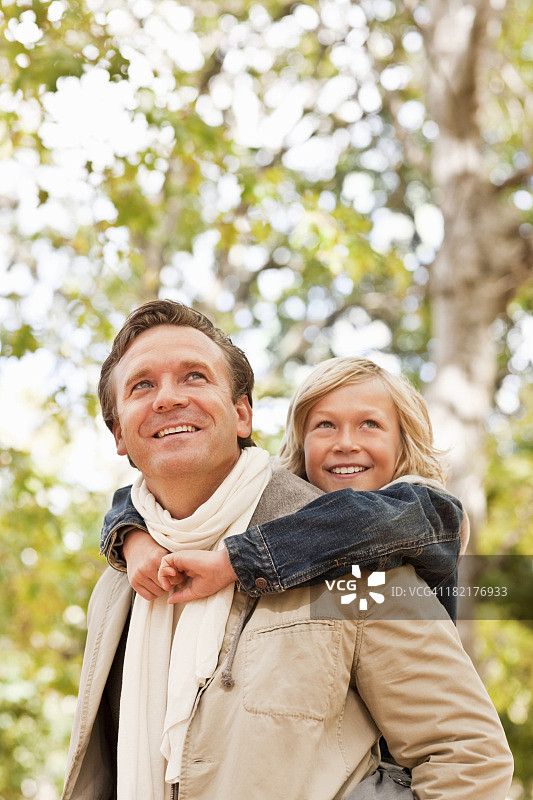 父亲背着儿子，看向远方图片素材