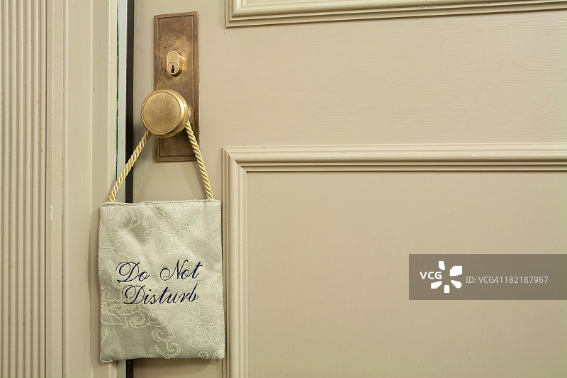 挂在米色门上的“请勿打扰”布艺标志图片素材