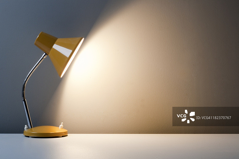 白色桌子上打开的黄色台灯轮廓图片素材
