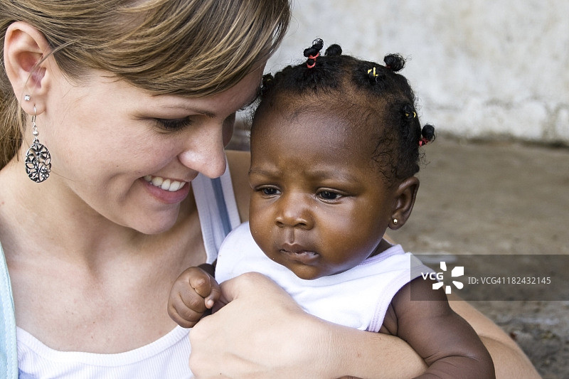 抱着非洲婴儿的美国女人图片素材