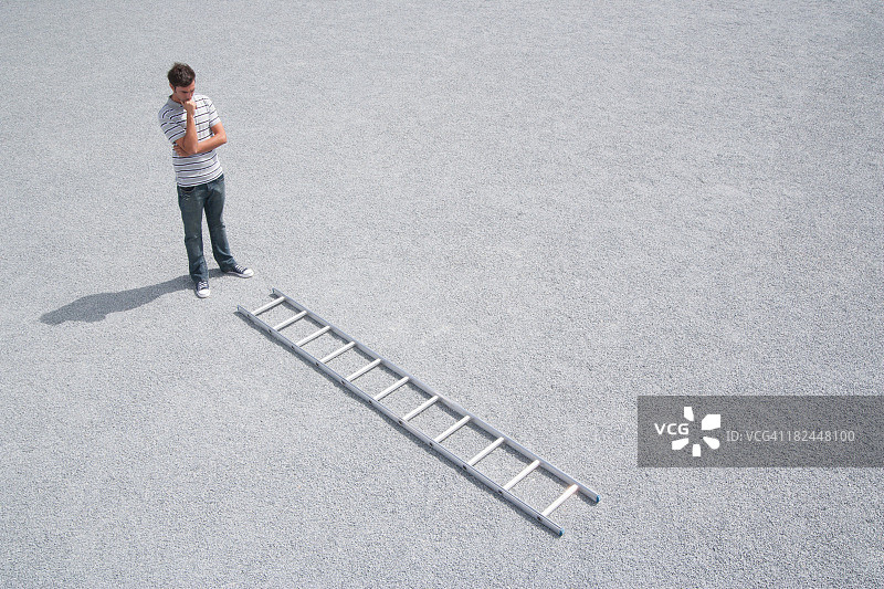 男子在户外看着梯子图片素材