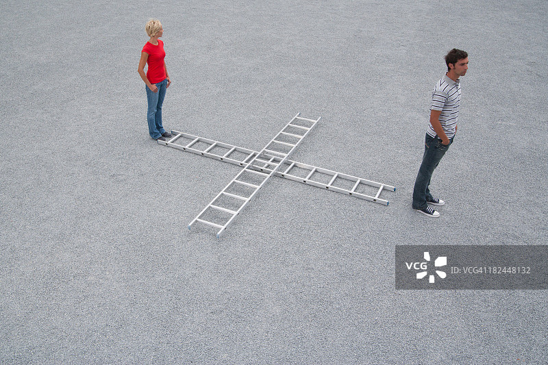 在户外与两个梯子站立的男人和女人图片素材
