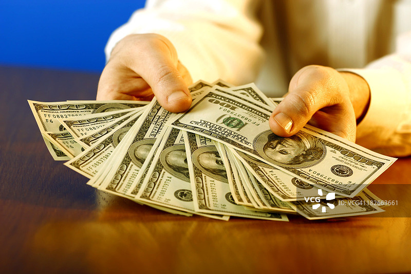 男人手持美元钞票图片素材