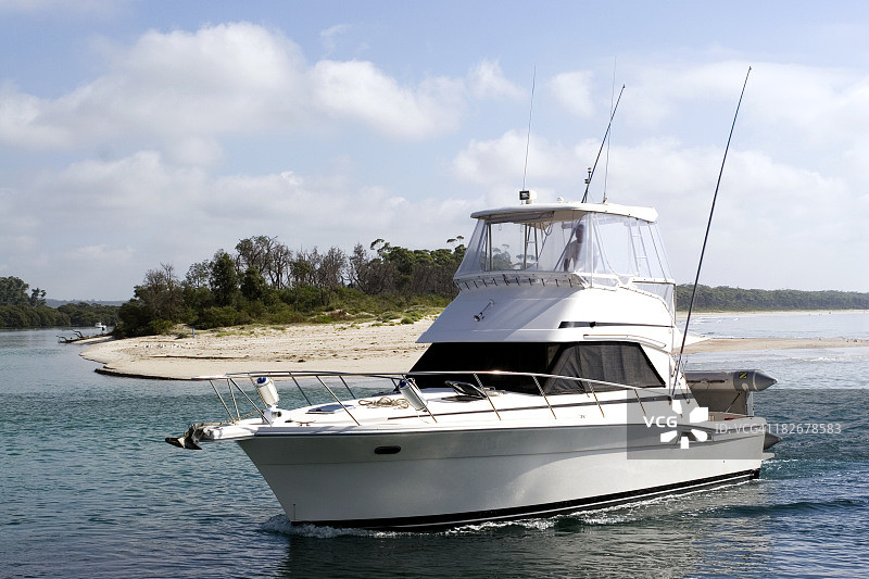 白色游艇驶过沙岸图片素材