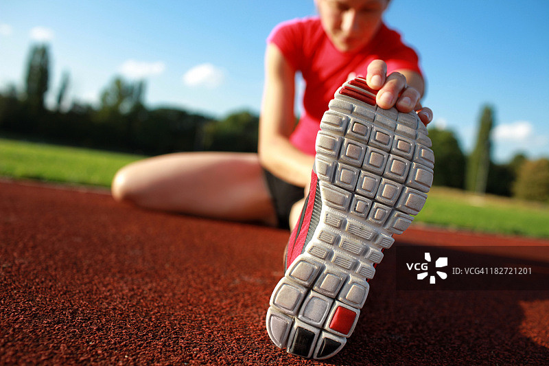 女人在跑道上伸展腿部的特写图片素材