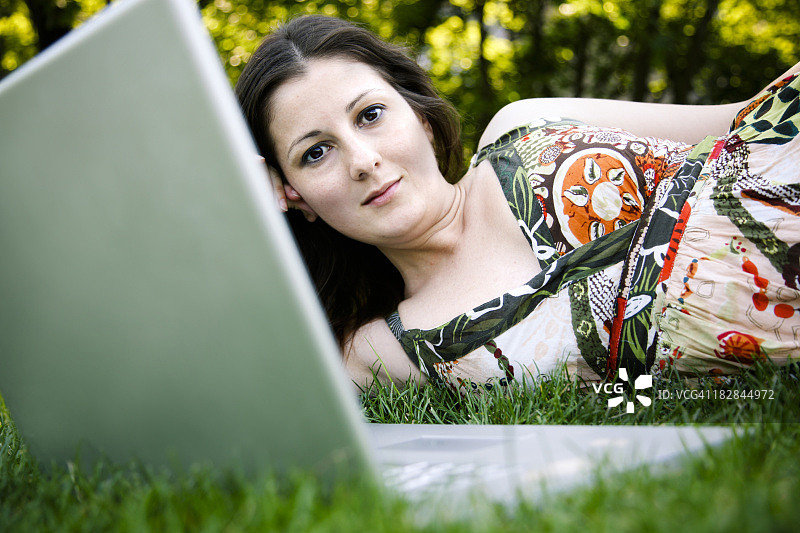 在户外使用笔记本电脑的年轻女人图片素材