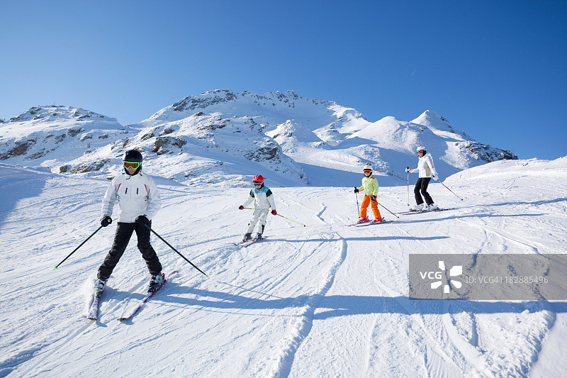 阳光明媚的家庭滑雪图片素材