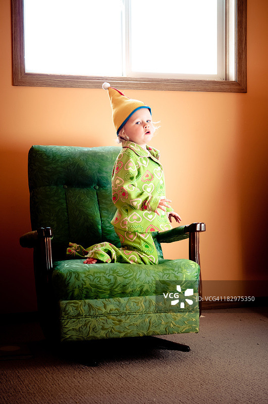 戴着小丑帽和穿着睡衣的幼儿女孩图片素材