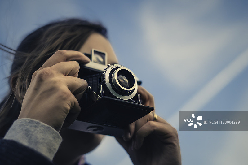 女人用35mm复古相机拍照图片素材