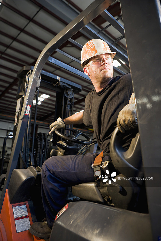 男人在仓库中操作叉车图片素材