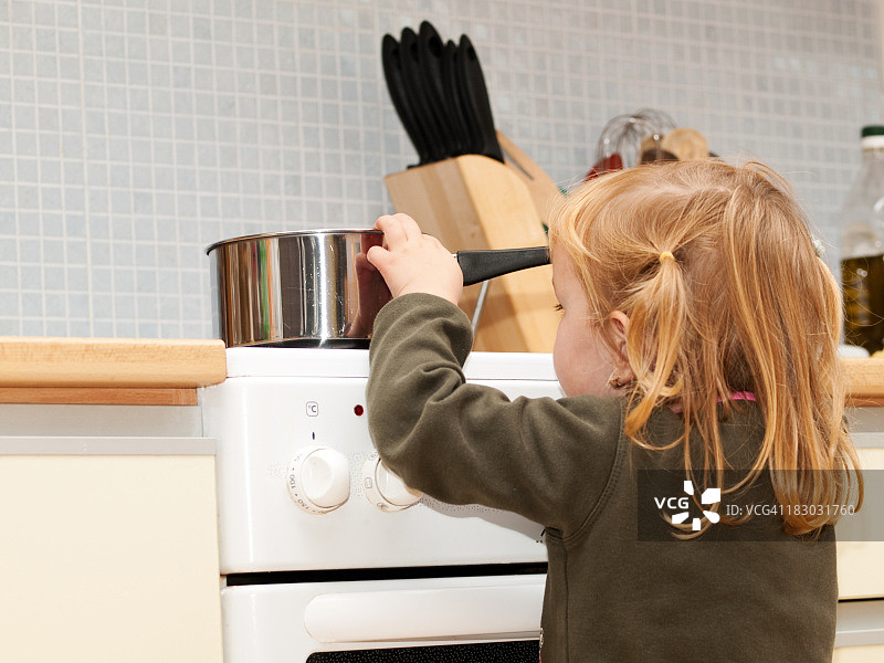 厨房里对金发小孩的炉灶危险图片素材