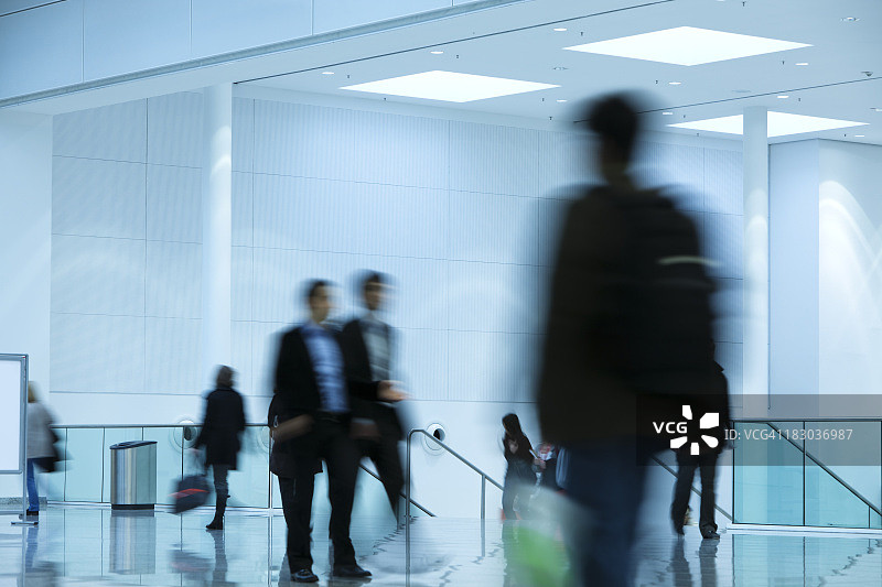 在现代室内行走的人们的模糊图像图片素材