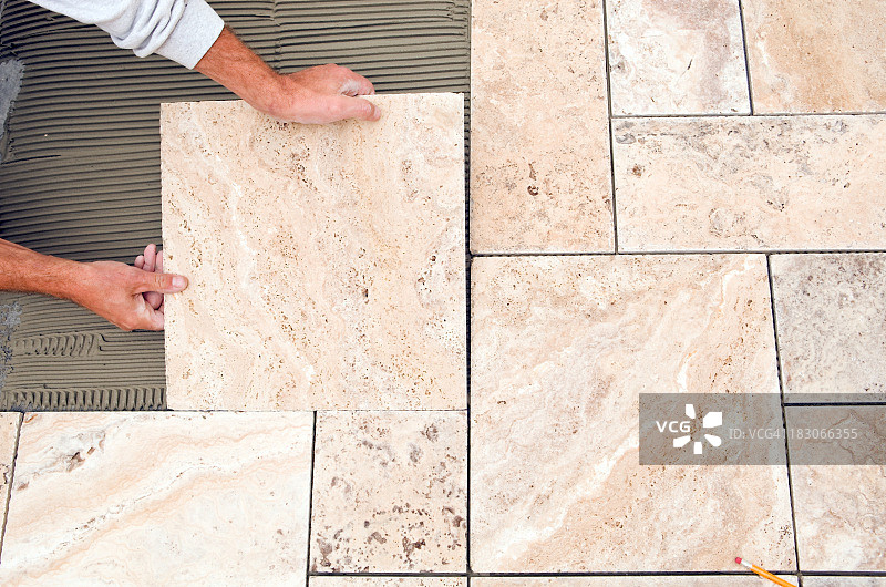工人在浴室地板上铺设新瓷砖图片素材